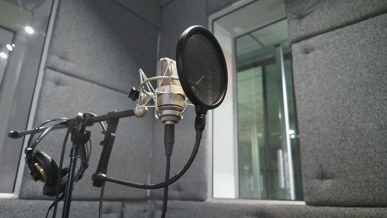 Studio microphone with pop filter and headphones in a treated vocal booth