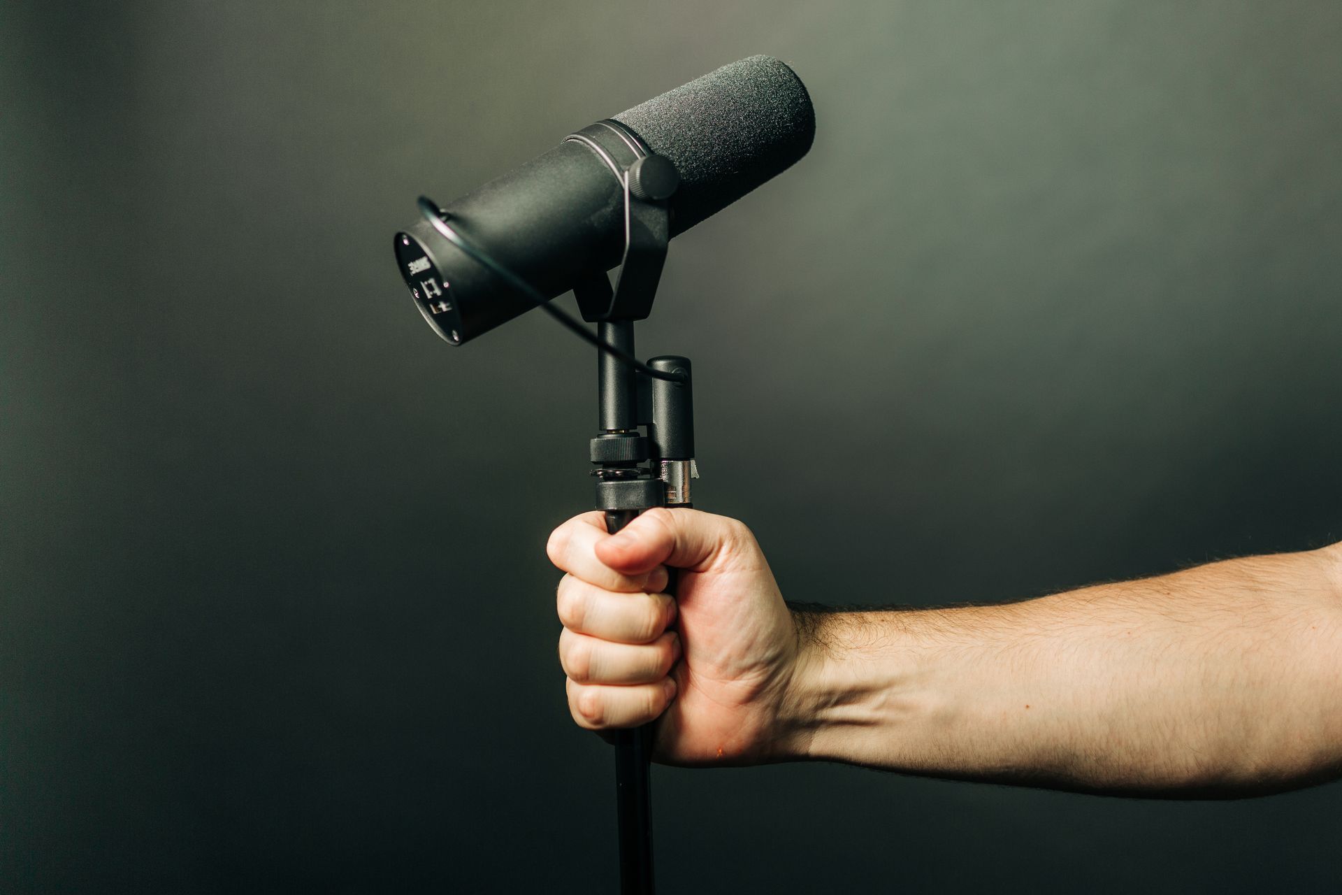 Hand gripping a professional studio microphone